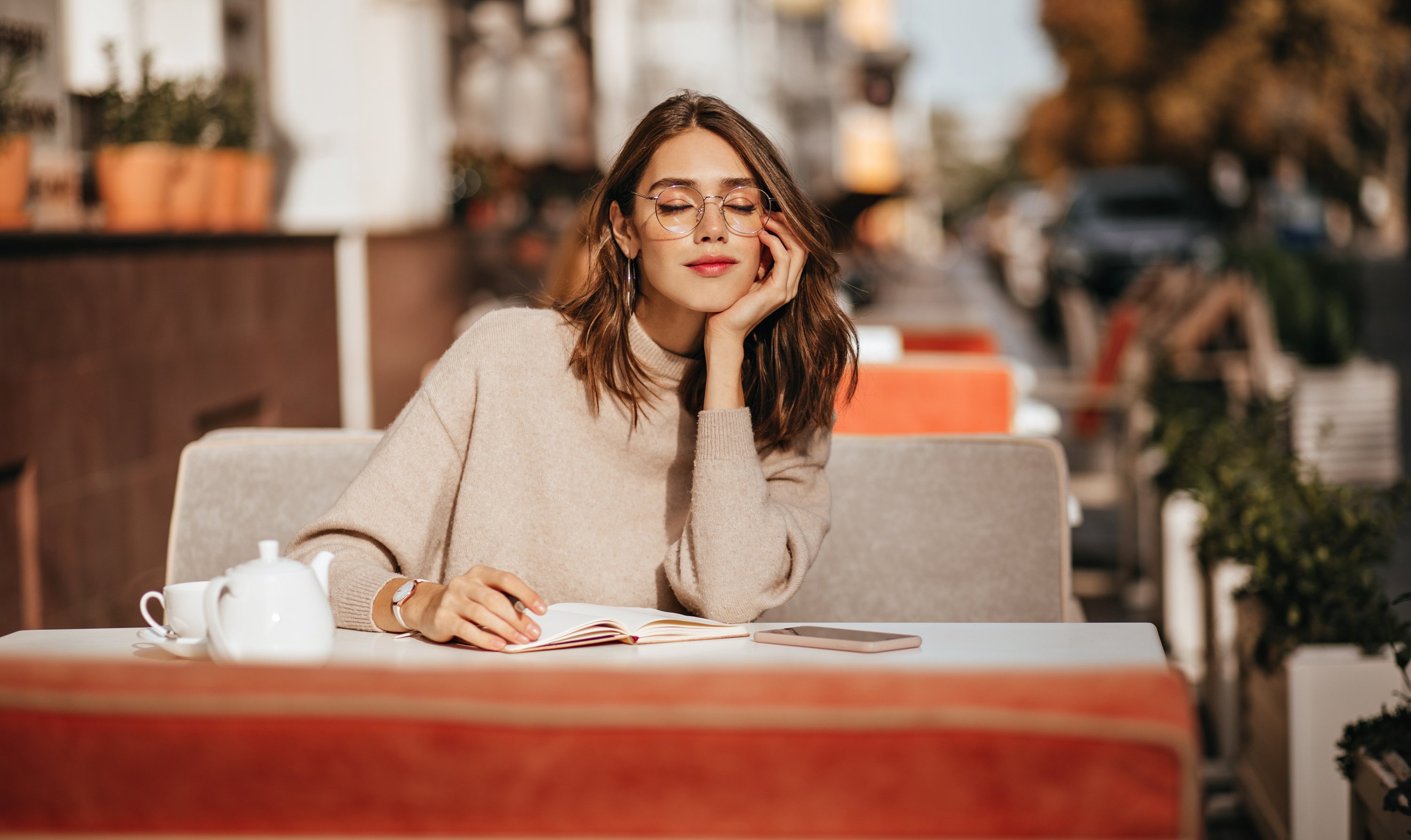 person sitting at a coffee shop who is peaceful and living mindfully